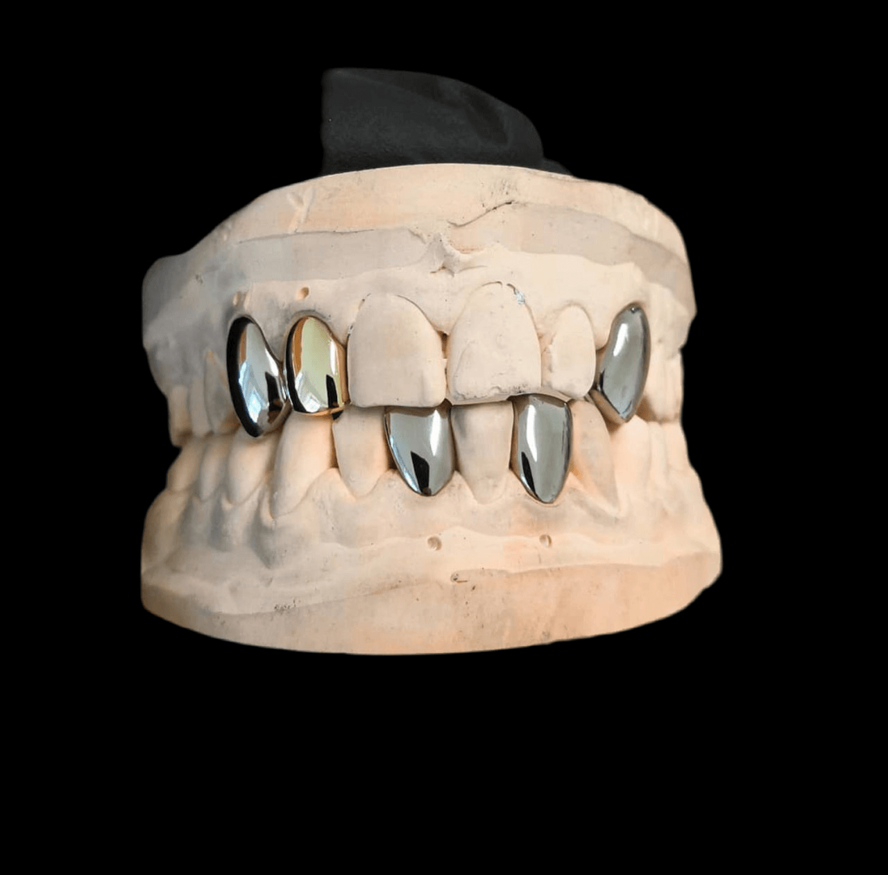 Jack Sparrow grillz in 9-karat white gold and silver, showcasing a sleek, modern design on a dental mold.